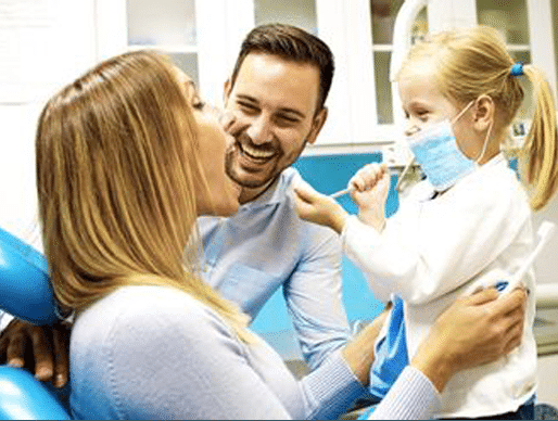 Couple laughing with their kid at dental office