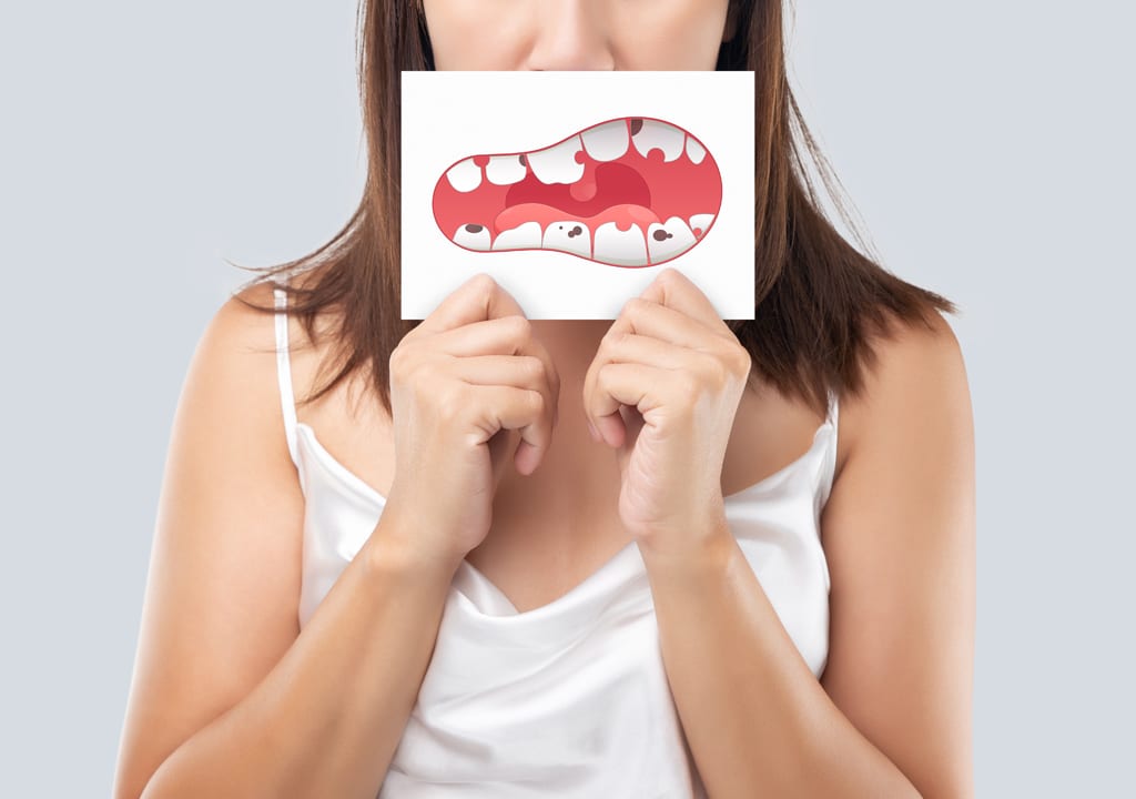 Girl is holding the image of broken teeth