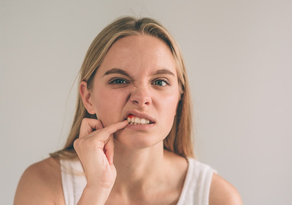 Girl is pointing finger on the bleeding tooth