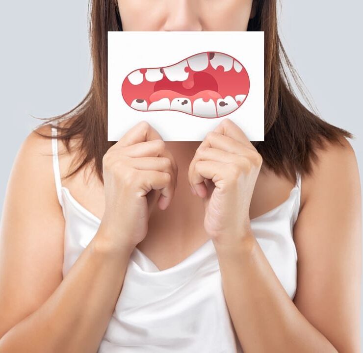 Girl is holding the image of broken teeth