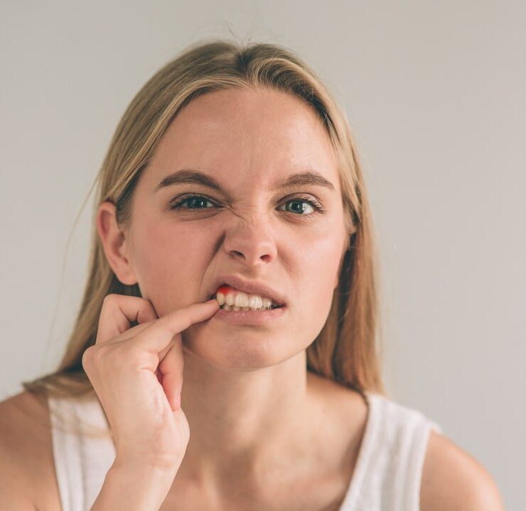 Girl is pointing finger on the bleeding tooth